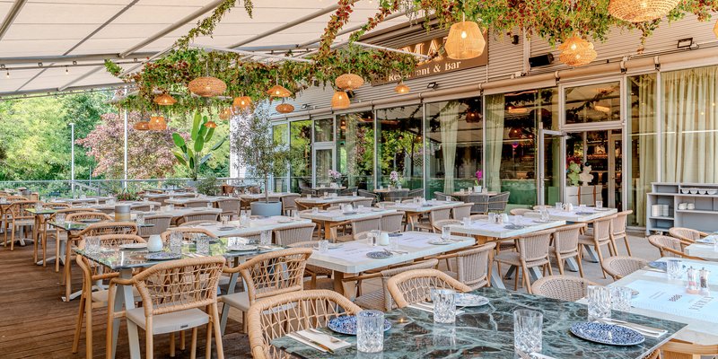 Kymata Modern - Gedeckte Terrasse unter der Pergola – mediterranes Ambiente für Sommerfeste und Firmenfeiern.